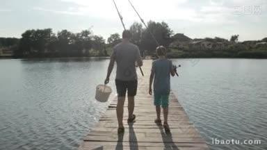 背影爸爸一<strong>手拎</strong>着水桶，十几岁的男孩拿着钓竿，沿着木质浮筒行走
